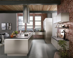 Durch die Ziegelwand kommt die INOX 216-Küche, im Look der Nachbildung von gebürstetem Stahl, ideal zur Geltung. Perfekt um so den den kühlen, klaren Industrial-Style in Ihrem Zuhause zu kreieren.   Durch die Ziegelwand kommt die INOX 216-Küche, im Look der Nachbildung von gebürstetem Stahl, ideal zur Geltung. Perfekt um so den den kühlen, klaren Industrial-Style in Ihrem Zuhause zu kreieren.