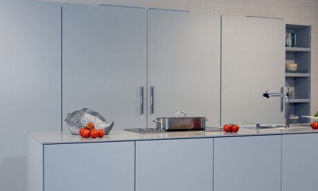 Küche mit grifflosen Schiebetüren und Kochinsel Küche mit grifflosen Schiebetüren und Kochinsel